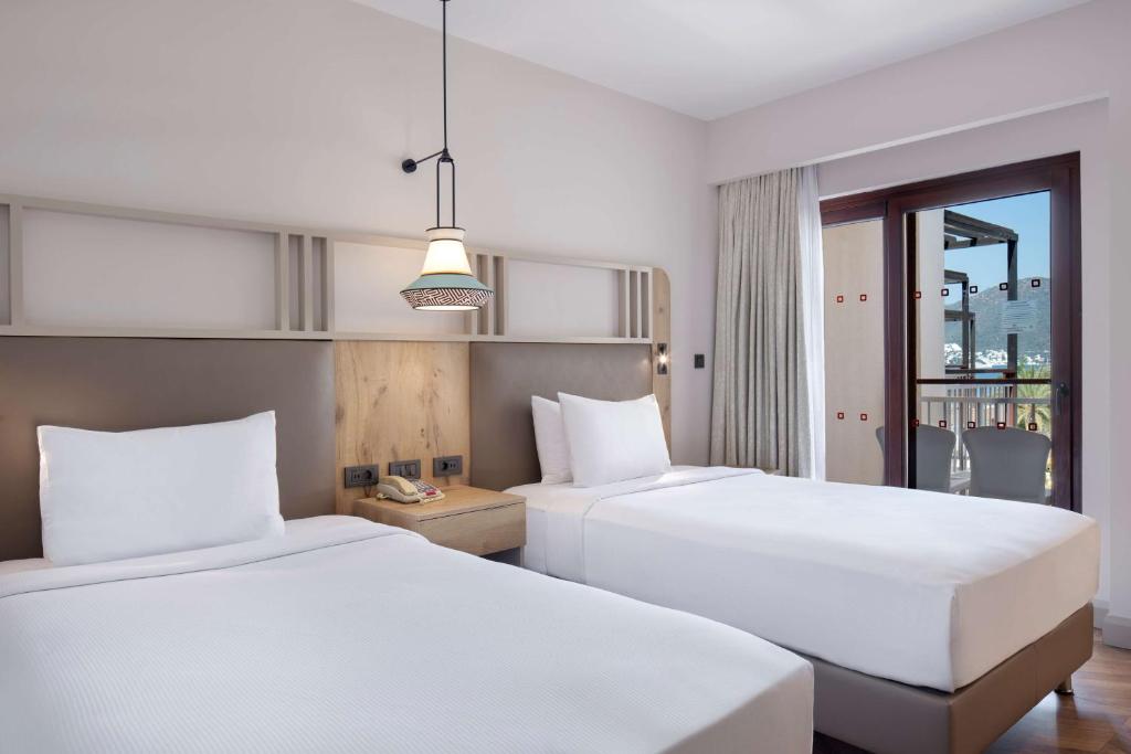 Кровать или кровати в номере DoubleTree by Hilton Bodrum Isil Club Ultra All-Inclusive Resort