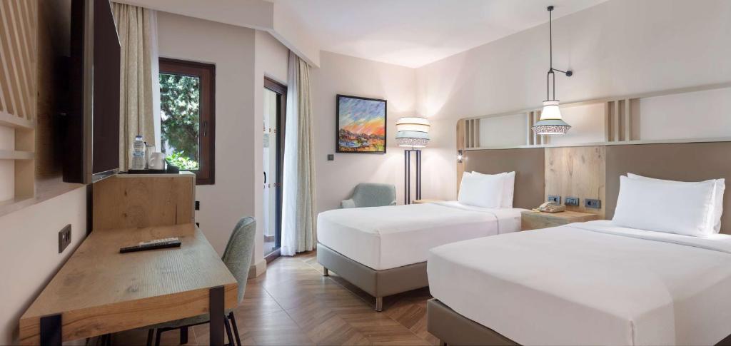Кровать или кровати в номере DoubleTree by Hilton Bodrum Isil Club Ultra All-Inclusive Resort