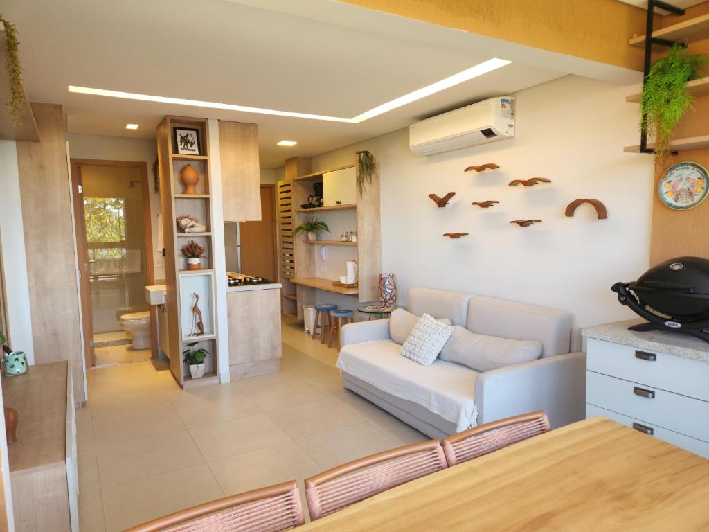 a living room with a couch and a kitchen at Eco Resort Praia dos Carneiros - Flat Novo - Ao Lado da Igrejinha in Praia dos Carneiros