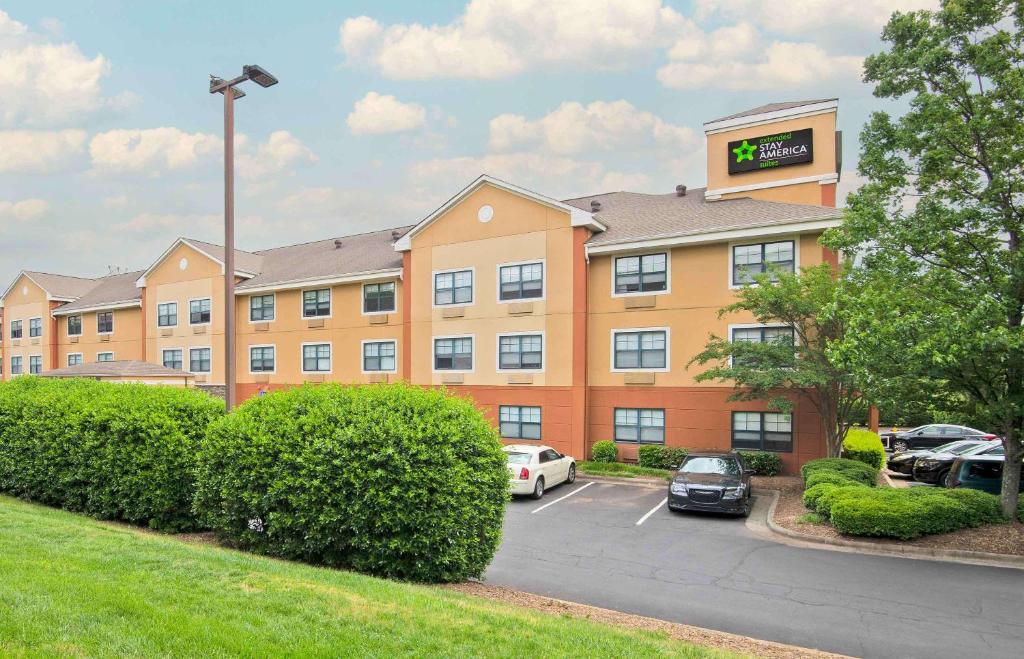ein Hotel mit Autos auf einem Parkplatz in der Unterkunft Extended Stay America Suites - Charlotte - Tyvola Rd in Charlotte