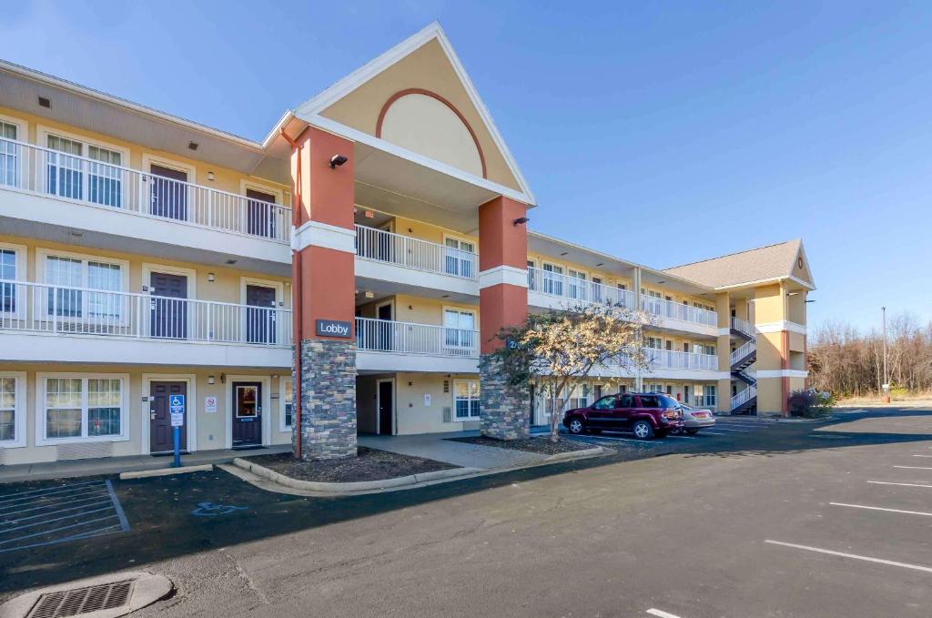 a large apartment building with a car parked in a parking lot at Extended Stay America Select Suites - Roanoke - Airport in Roanoke