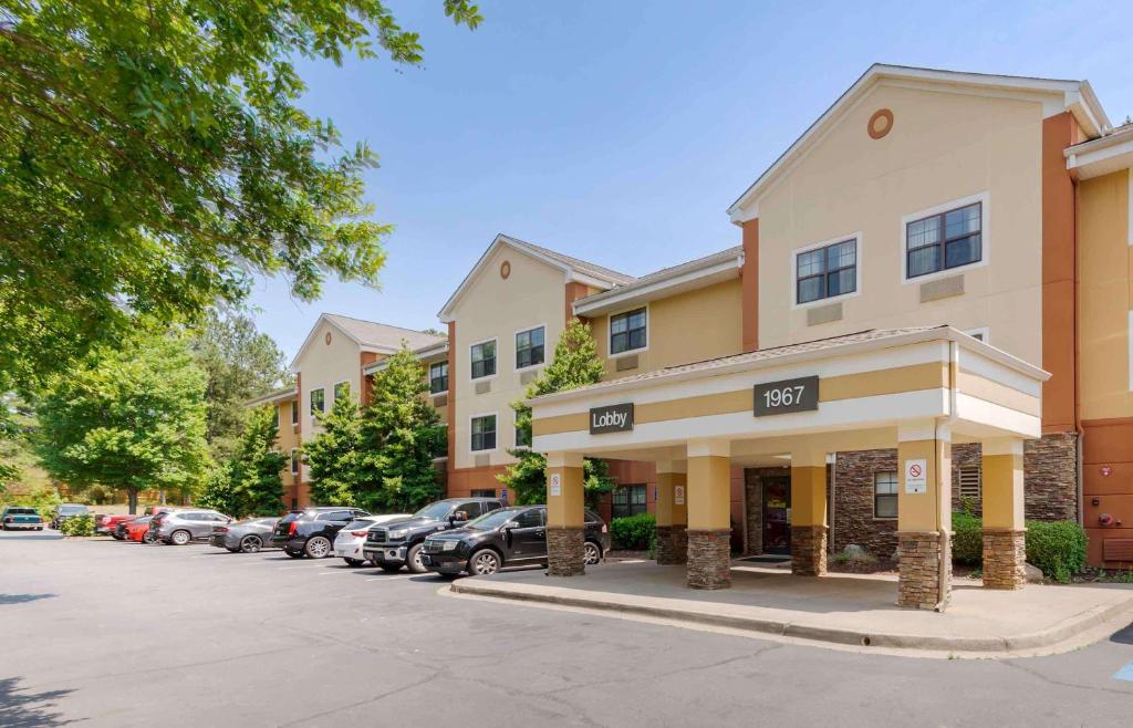 un edificio con coches estacionados en un estacionamiento en Extended Stay America Suites - Atlanta - Marietta - Windy Hill en Atlanta