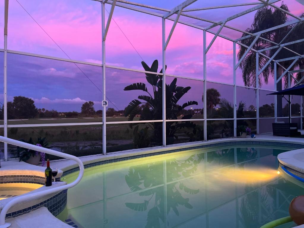 a swimming pool with a sunset in the background at Entire home with pool and lake view and Golf course by Disney in Davenport