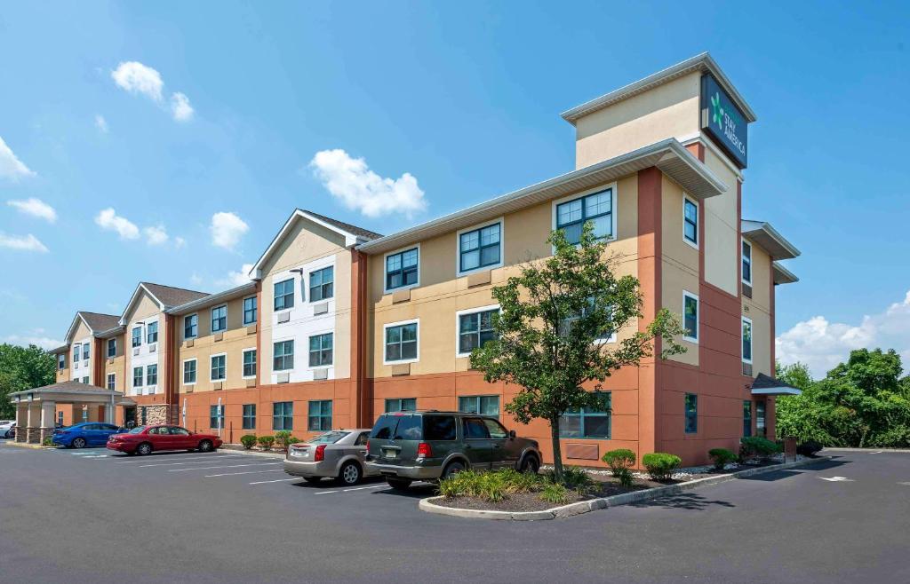 duży budynek z samochodami zaparkowanymi na parkingu w obiekcie Extended Stay America Suites - Philadelphia - Cherry Hill w mieście Maple Shade