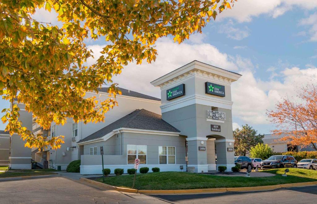 a large white building with two clocks on it at Extended Stay America Suites - Kansas City - Lenexa - 87th St in Overland Park
