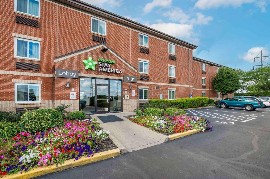 a hotel with flowers in front of a building at Extended Stay America Suites - Dayton - Fairborn in Dayton