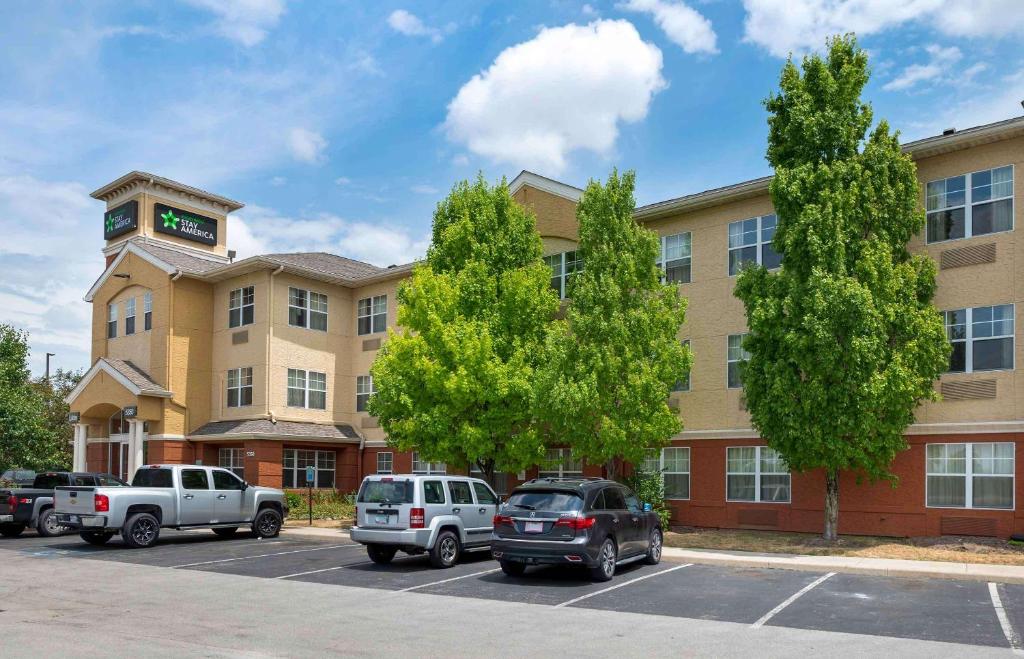 un edificio con coches estacionados en un estacionamiento en Extended Stay America Suites - Indianapolis - Airport - W Southern Ave en Indianápolis