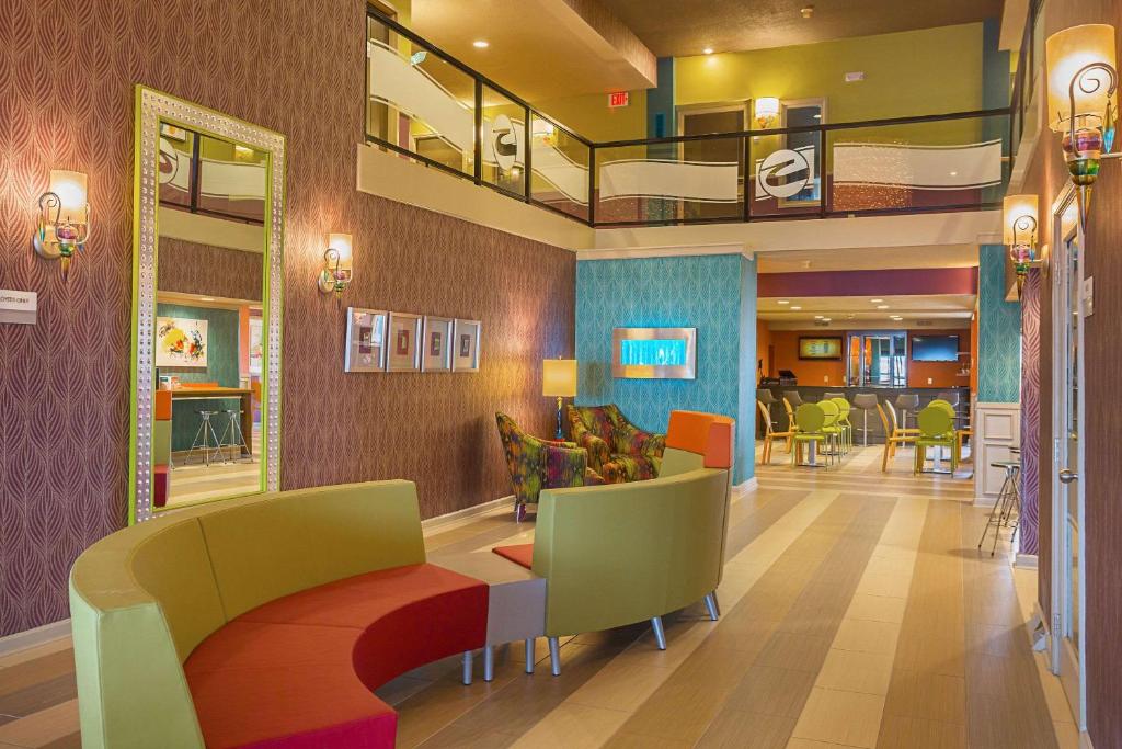 un vestíbulo de un hospital con sillas y mesas en Clarion Inn & Suites, en Evansville