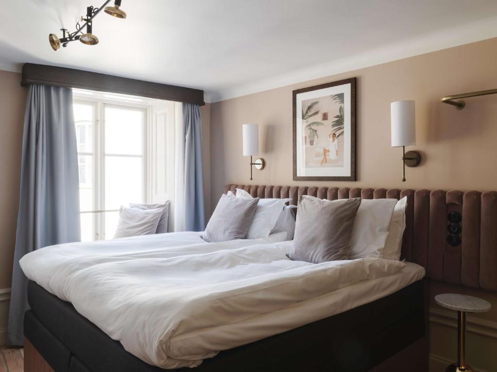 a large bed in a bedroom with a window at Hotel Frantz, WorldHotels Crafted in Stockholm