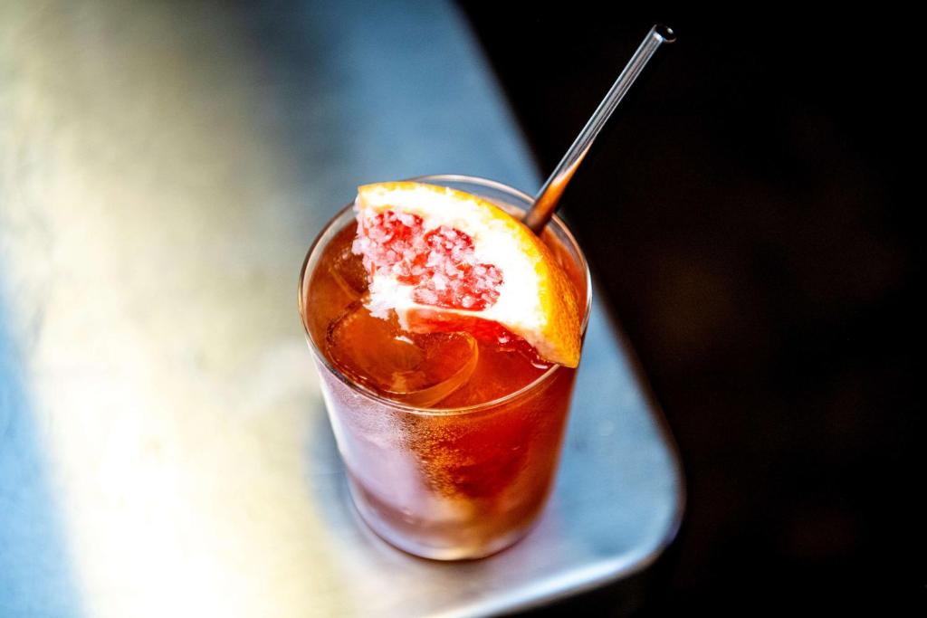 a drink with an orange slice in a glass on a plate at Hotel Frantz, WorldHotels Crafted in Stockholm