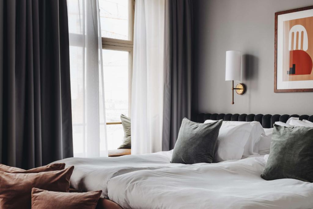 a bedroom with a bed with pillows and a window at Hotel Frantz, WorldHotels Crafted in Stockholm