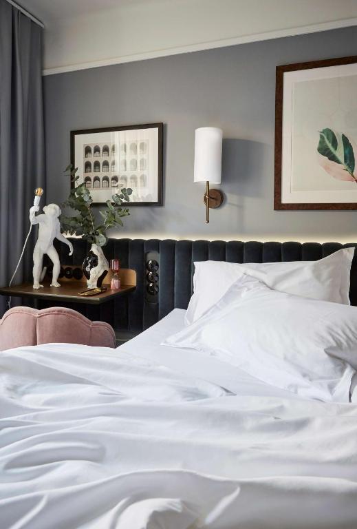 a bedroom with a white bed and a table with a plant at Hotel Frantz, WorldHotels Crafted in Stockholm