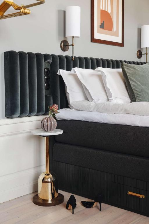 a bed with black and white pillows and a table at Hotel Frantz, WorldHotels Crafted in Stockholm