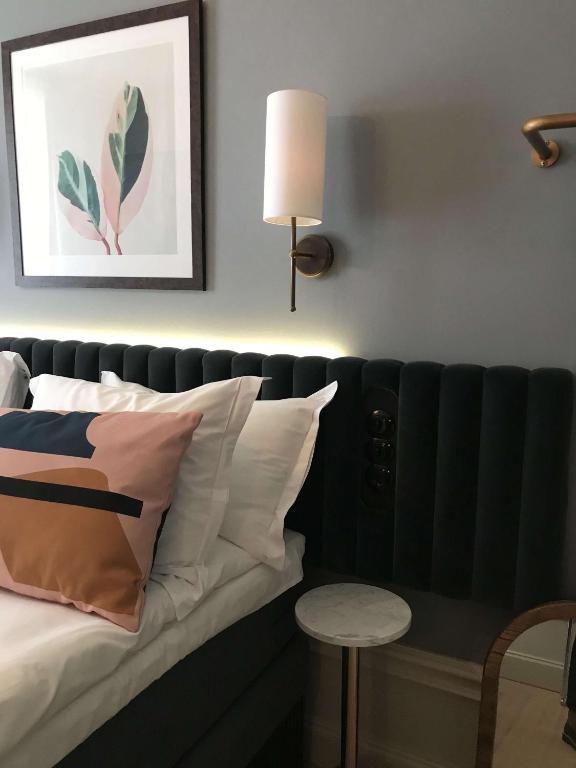 a bedroom with a bed and a lamp and a table at Hotel Frantz, WorldHotels Crafted in Stockholm
