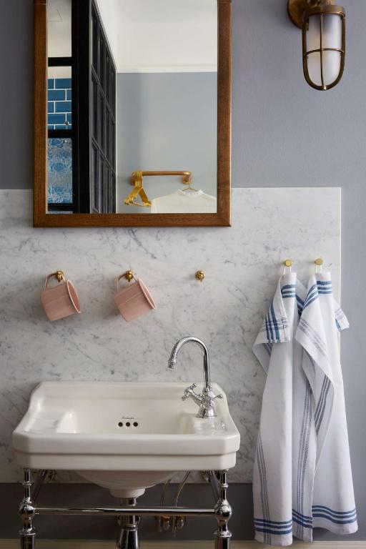 a bathroom with a sink and a mirror and towels at Hotel Frantz, WorldHotels Crafted in Stockholm
