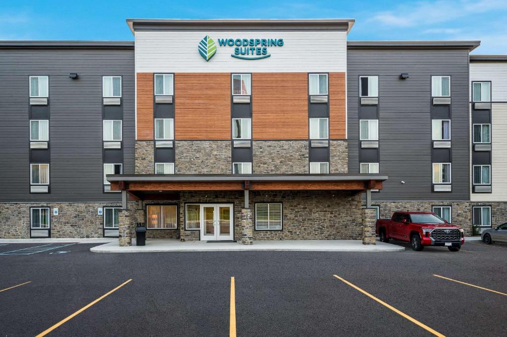 a building with a sign on the front of it at WoodSpring Suites Wixom - Novi in Wixom