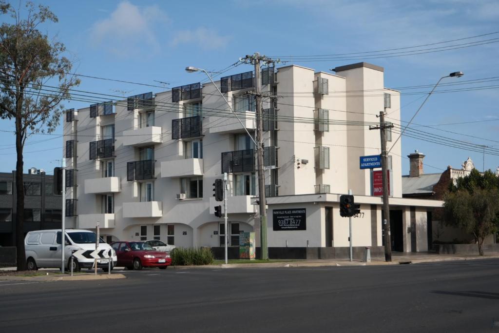 un grande edificio bianco all'angolo di una strada di Parkville Place Serviced Apartments a Melbourne