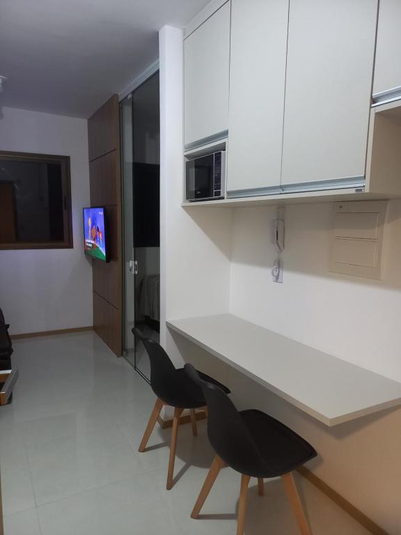uma cozinha com uma mesa branca e 2 cadeiras em Apartamento Temporada Salvador Pituba em Salvador