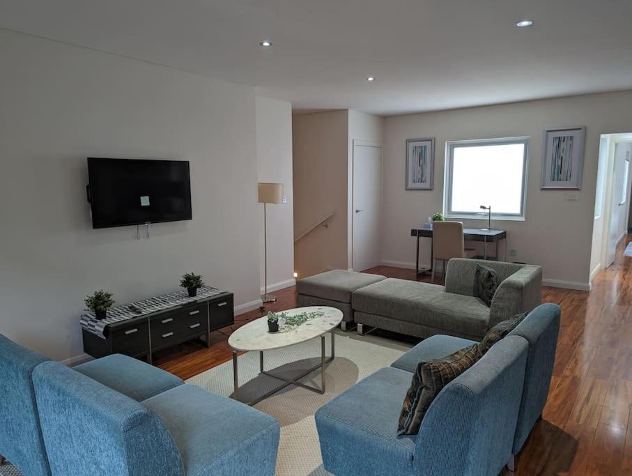 a living room with two blue couches and a tv at Spacious 2 bedroom apartment @Kingston Foreshore in Kingston 