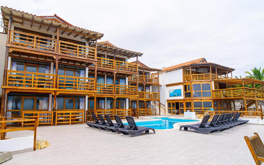 a large building with a swimming pool and lounge chairs at Hotel Route 66 in Vichayito