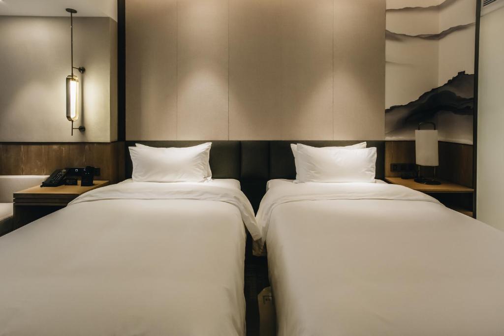 Postel nebo postele na pokoji v ubytování Orienwit Hotel-Free Shuttle Bus fir Canton Fair