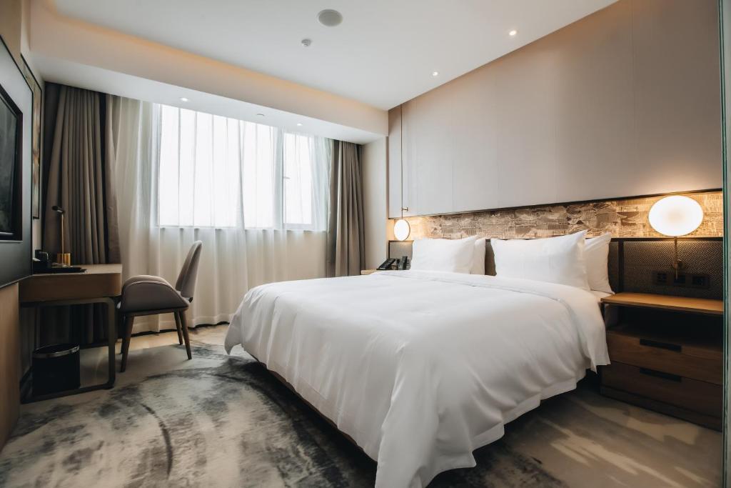 Postel nebo postele na pokoji v ubytování Orienwit Hotel-Free Shuttle Bus fir Canton Fair