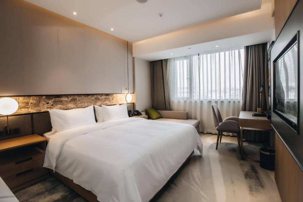 Postel nebo postele na pokoji v ubytování Orienwit Hotel-Free Shuttle Bus fir Canton Fair