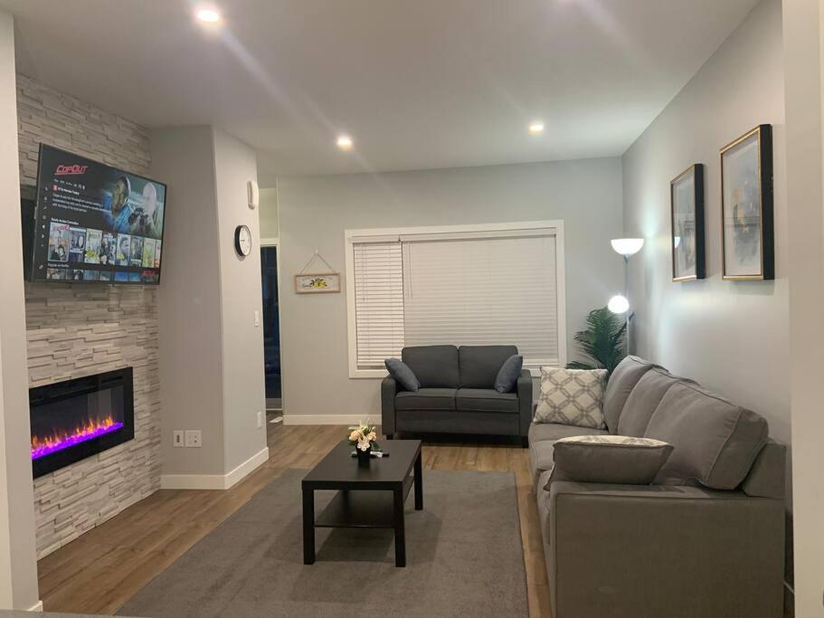 a living room with a couch and a fireplace at Luxurious 3 BR Villa with free parking - King Bed in Regina