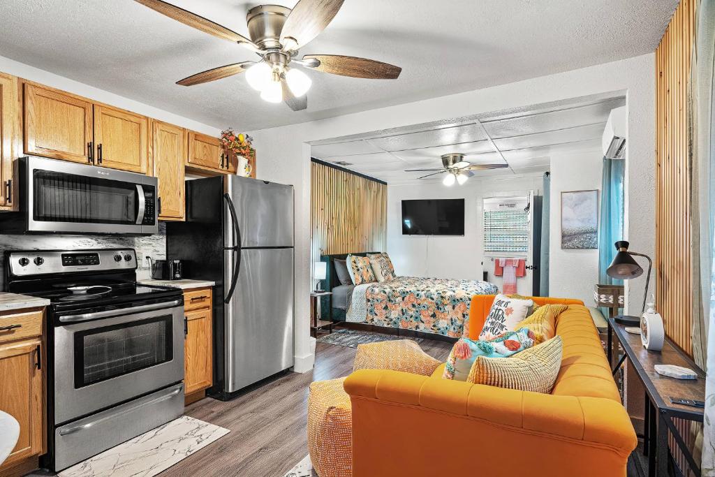 a kitchen and a living room with a couch and a stove at Orange Blossom Place-Walk to shops bars & food in Tampa