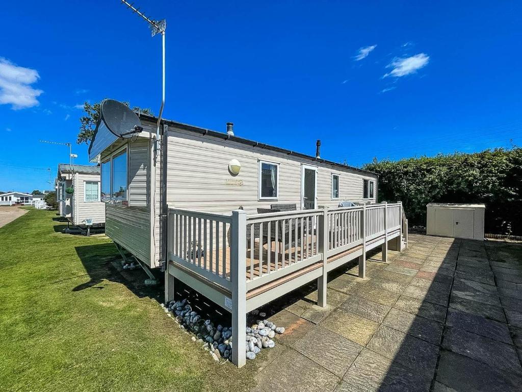a mobile home with a porch and a deck at Superb 6 Berth, Dog Friendly Caravan For Hire By The Beach In Norfolk Ref 50008m in Great Yarmouth
