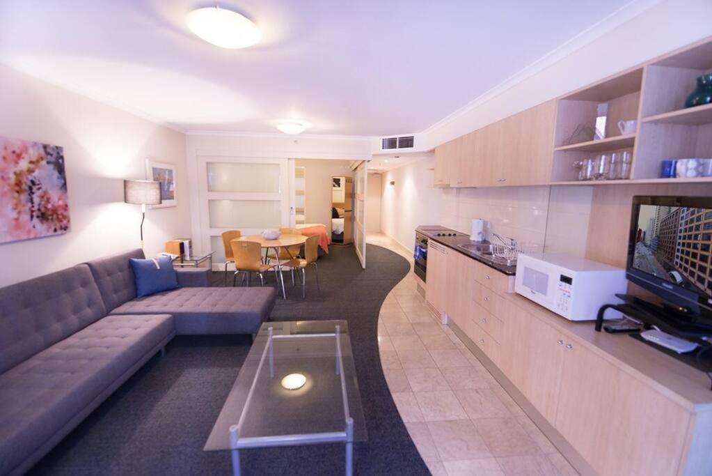 een woonkamer met een bank en een eetkamer bij PI702 - Ideally Located Sydney CBD in Sydney