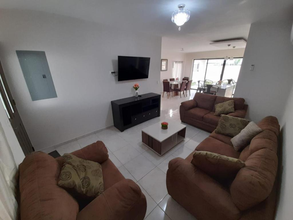 ein Wohnzimmer mit Sofas und einem Flachbild-TV in der Unterkunft House in San Miguel, Res. San Andres in San Miguel