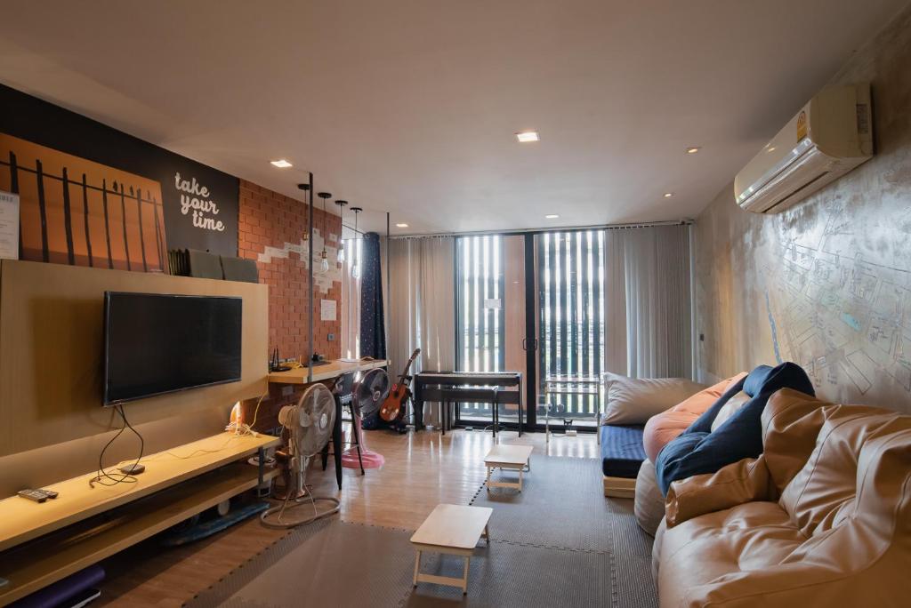 sala de estar con sofá y TV de pantalla plana en Cazz Hostel, en Bangkok