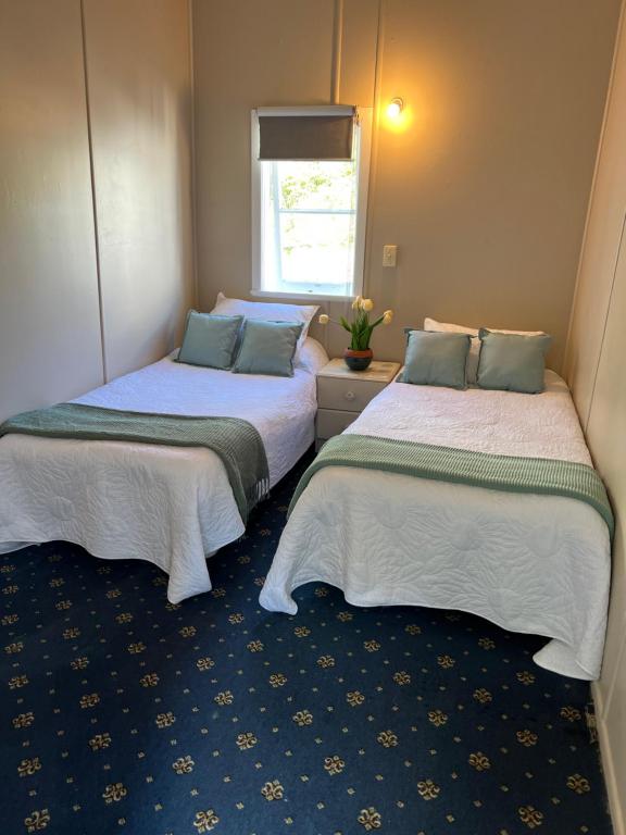 twee bedden naast elkaar in een kamer bij FISHERMANS’DELIGHT in Whangaroa