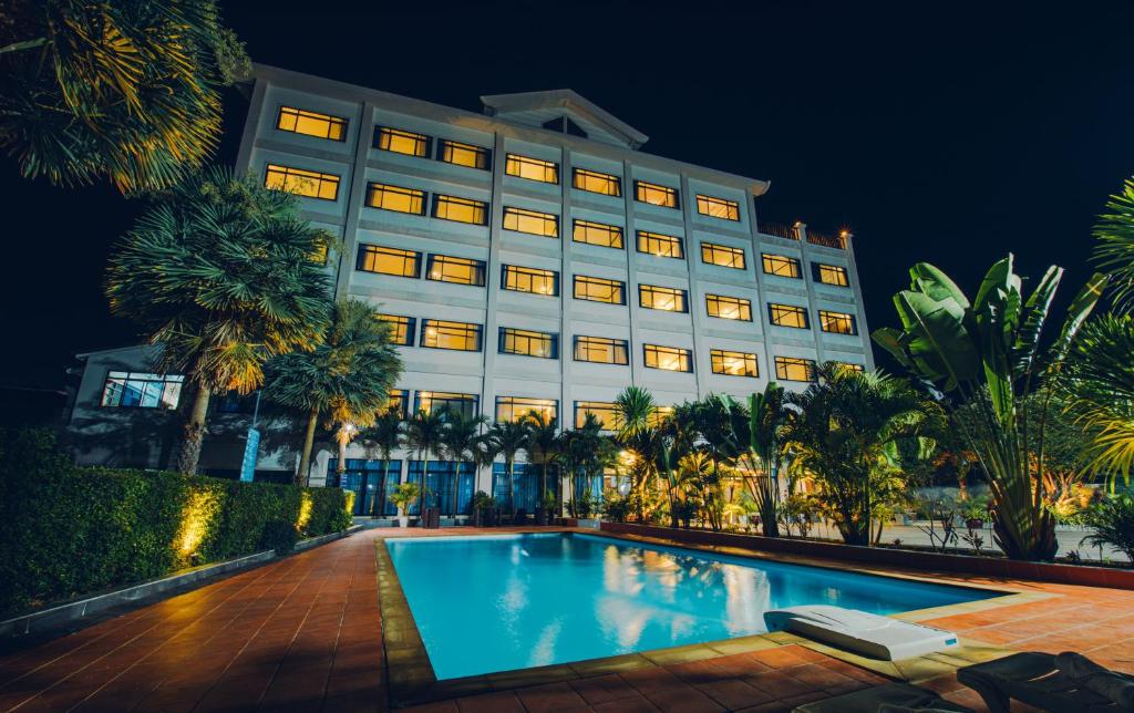 a hotel with a swimming pool at night at Sisombat Plaza Hotel in Vang Vieng