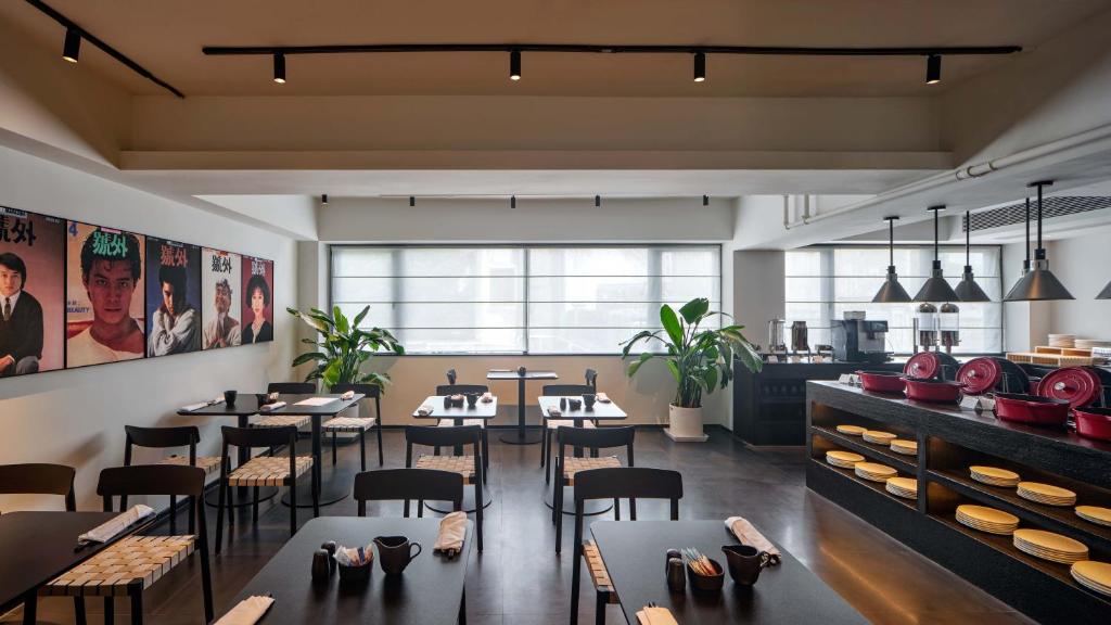 a restaurant with tables and chairs in a room at Jiangnan House Chaozhou in Chaozhou