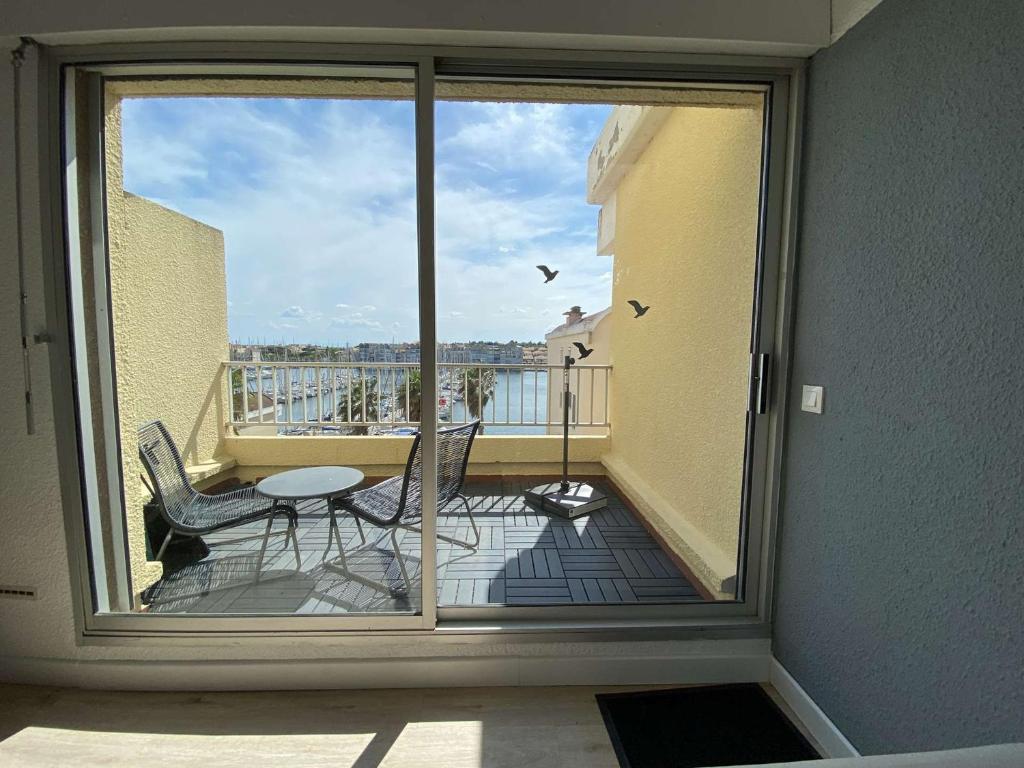une vue d'un balcon avec une table et des chaises dans l'établissement Spacieux T3, 2 chambres, parking privé à Gruissan - FR-1-229-876, à Gruissan
