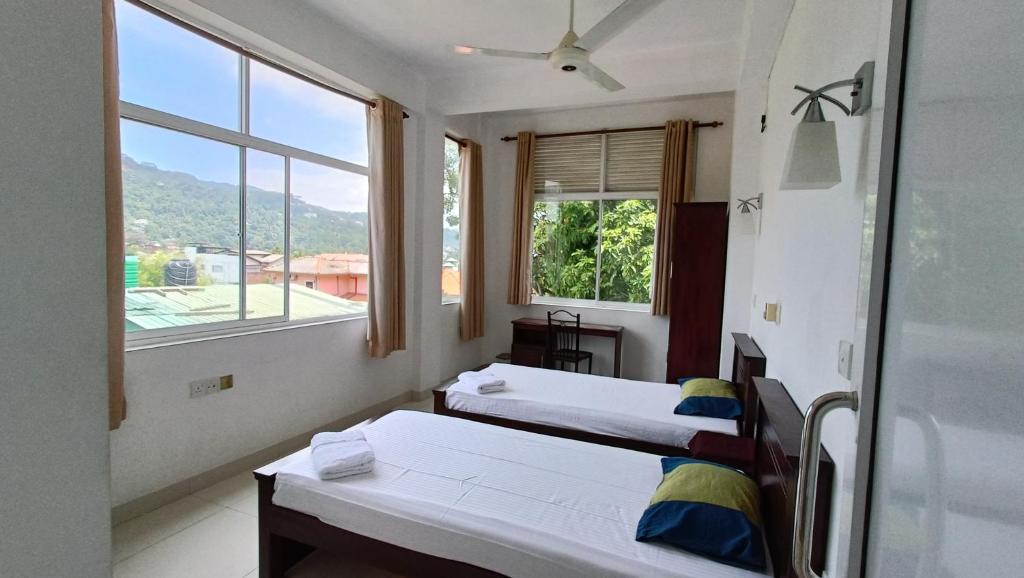 a room with two beds and a window at Smile Hub Kandy in Kandy