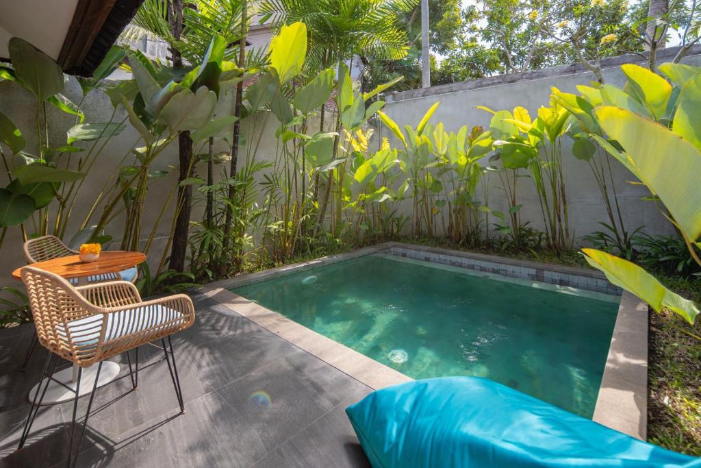 a small swimming pool with a table and chairs at Ecozy Dijiwa Canggu in Canggu