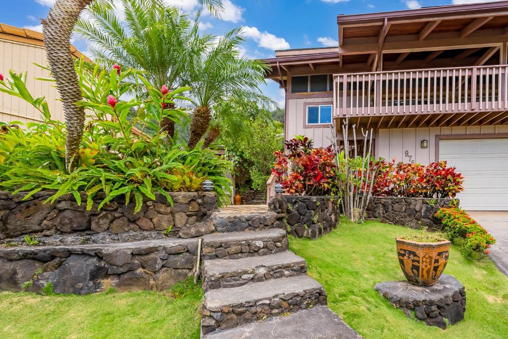 a yard with a stone retaining wall and a house at Seabreeze Hideaway B 30 Night Minimum in Honolulu