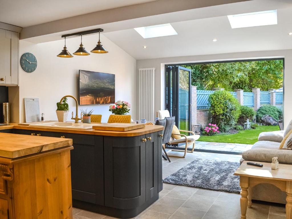 uma cozinha em plano aberto e sala de estar com uma grande porta de vidro deslizante em Rowan House em Beverley