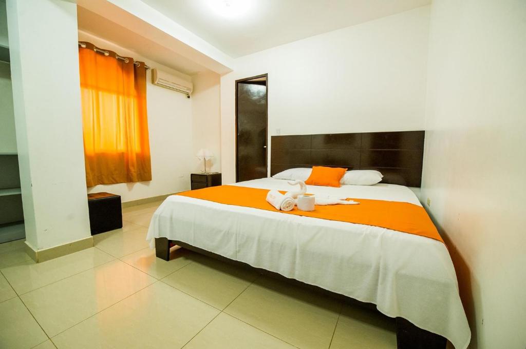 Un dormitorio con una cama grande con dos animales de peluche. en Hotel Luxor Pucallpa, en Pucallpa