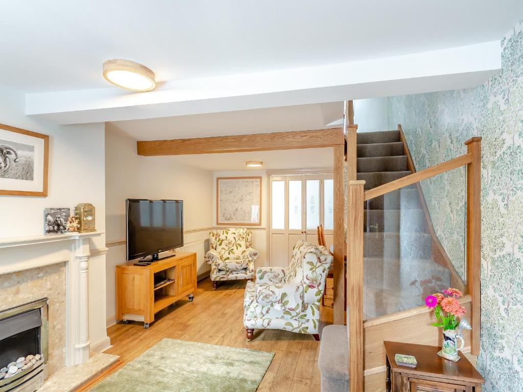 a living room with a fireplace and a television at Workshop Cottage in Rawcliffe