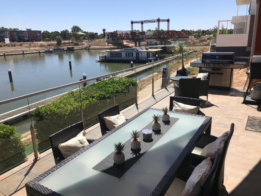 a table on a balcony with a view of a river at Clearview Waters - 4 King bedrooms, 3 bathrooms & views in Mildura