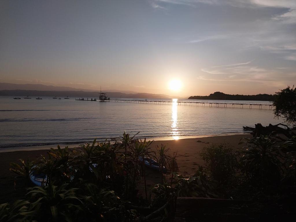 un tramonto sull'acqua con un molo di Happy Monkeys a Puerto Jiménez