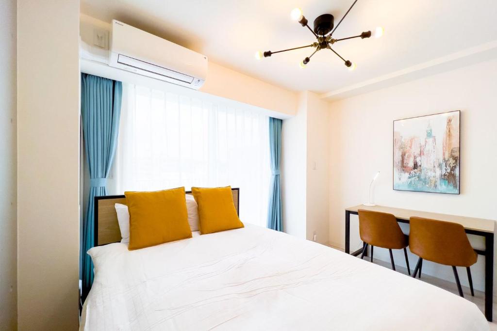 una camera da letto con letto con cuscini gialli e scrivania di Sakuramichi Terrace a Tokyo