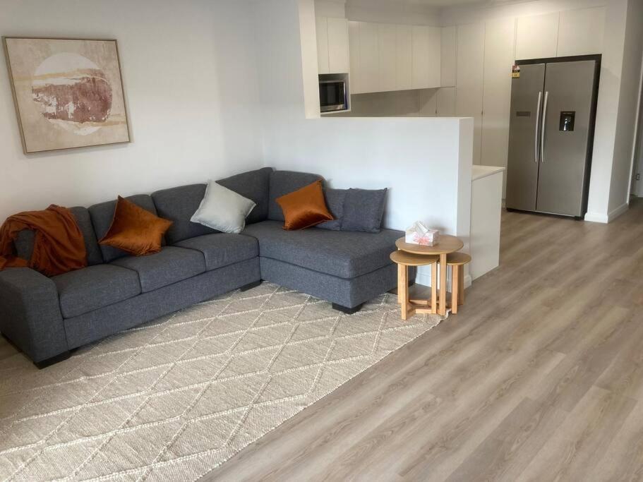 a living room with a blue couch and a kitchen at Kincaid@234 in Wagga Wagga