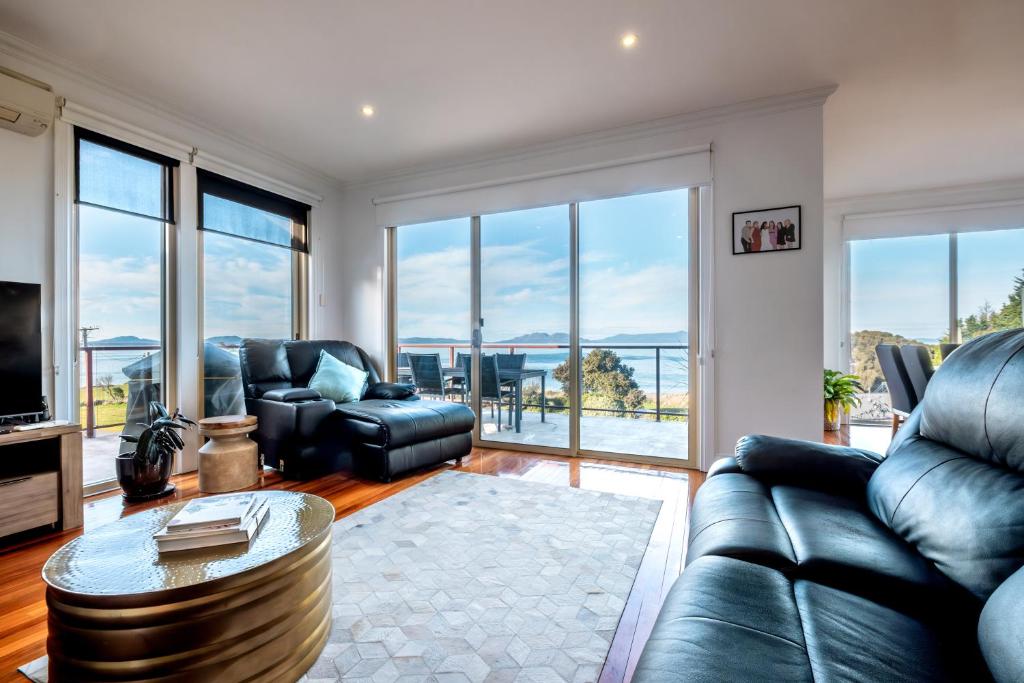 a living room with a couch and a table at Ensorcelled - Freycinet Holiday Houses in Swansea