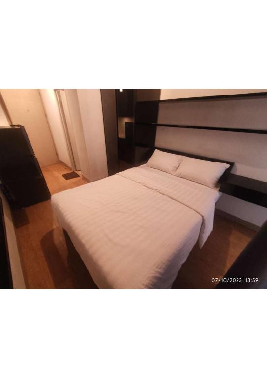 的住宿－Apartemen Tokyo Riverside Tower Dotonbori LT 12，一间卧室配有带白色床单和枕头的床。
