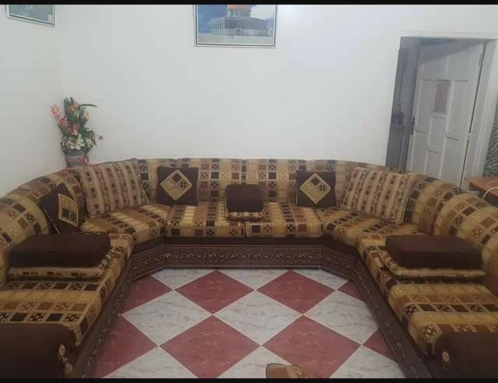 um grande sofá numa sala de estar com piso em xadrez em المساكن 